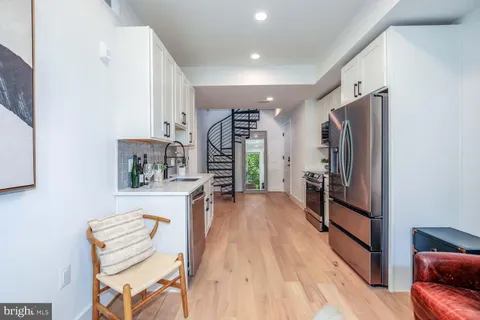 a kitchen with wooden floors cabinets a sink and appliances