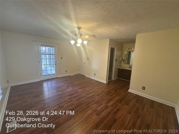 an empty room with wooden floor and window