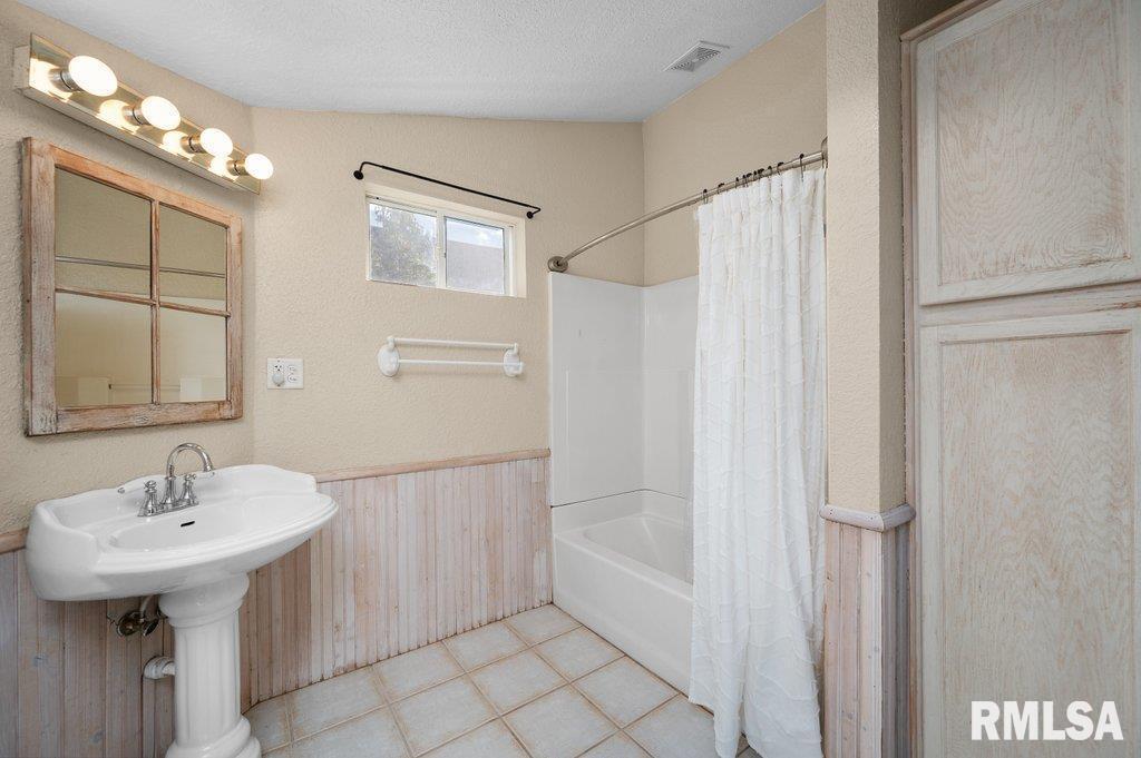216 North Boss Street Kewanee, IL 61443 - Photo 16 of 36 a bathroom with a sink a mirror and a shower