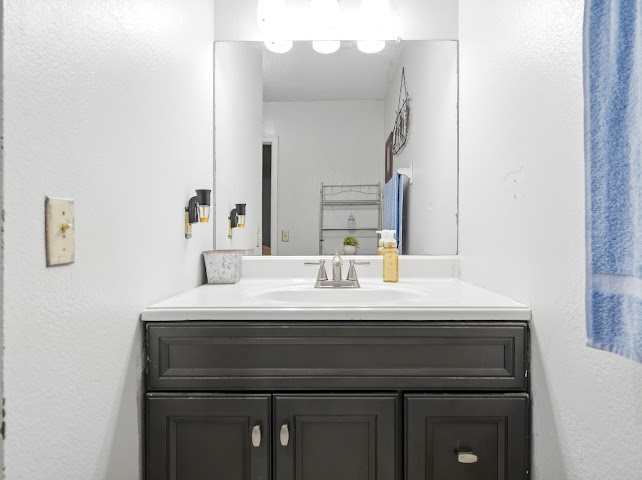 30063 South 4300th Road Stigler, OK 74462 - Photo 23 of 58 Vanity with integrated sink, chrome faucet, and dark wood-finish cabinetry