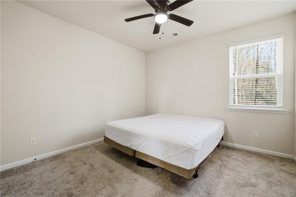 175 Paxton Lane Jefferson, GA 30549 - Photo 23 of 39 a bed sitting in a bedroom next to a window