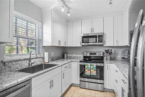 a kitchen with stainless steel appliances granite countertop a sink stove and microwave
