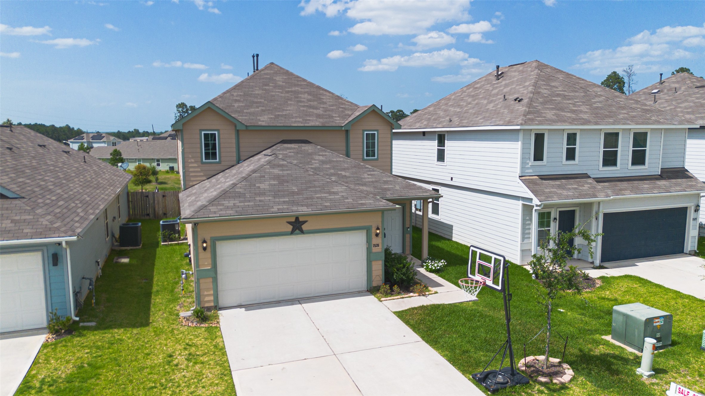 2526 Sturgeon Way Conroe, TX 77384 - Photo 45 of 49 This is a two-story home with a beige exterior featuring a two-car garage. It has a neatly maintained front yard. The house is in a suburban neighborhood with similar-style homes nearby.