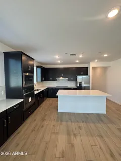 a large kitchen with stainless steel appliances a large counter top