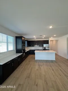 a large room with kitchen island a sink wooden floor and view living room