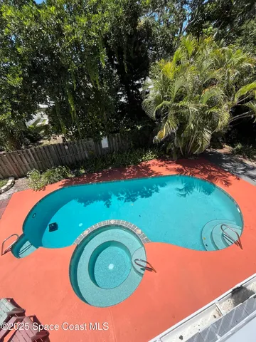 a view of a swimming pool with a yard and plants