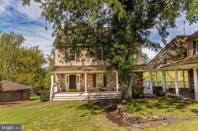a view of a brick house with large windows and a large tree
