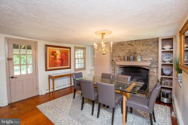 a bedroom with a bed and a lamp on dresser with a large window