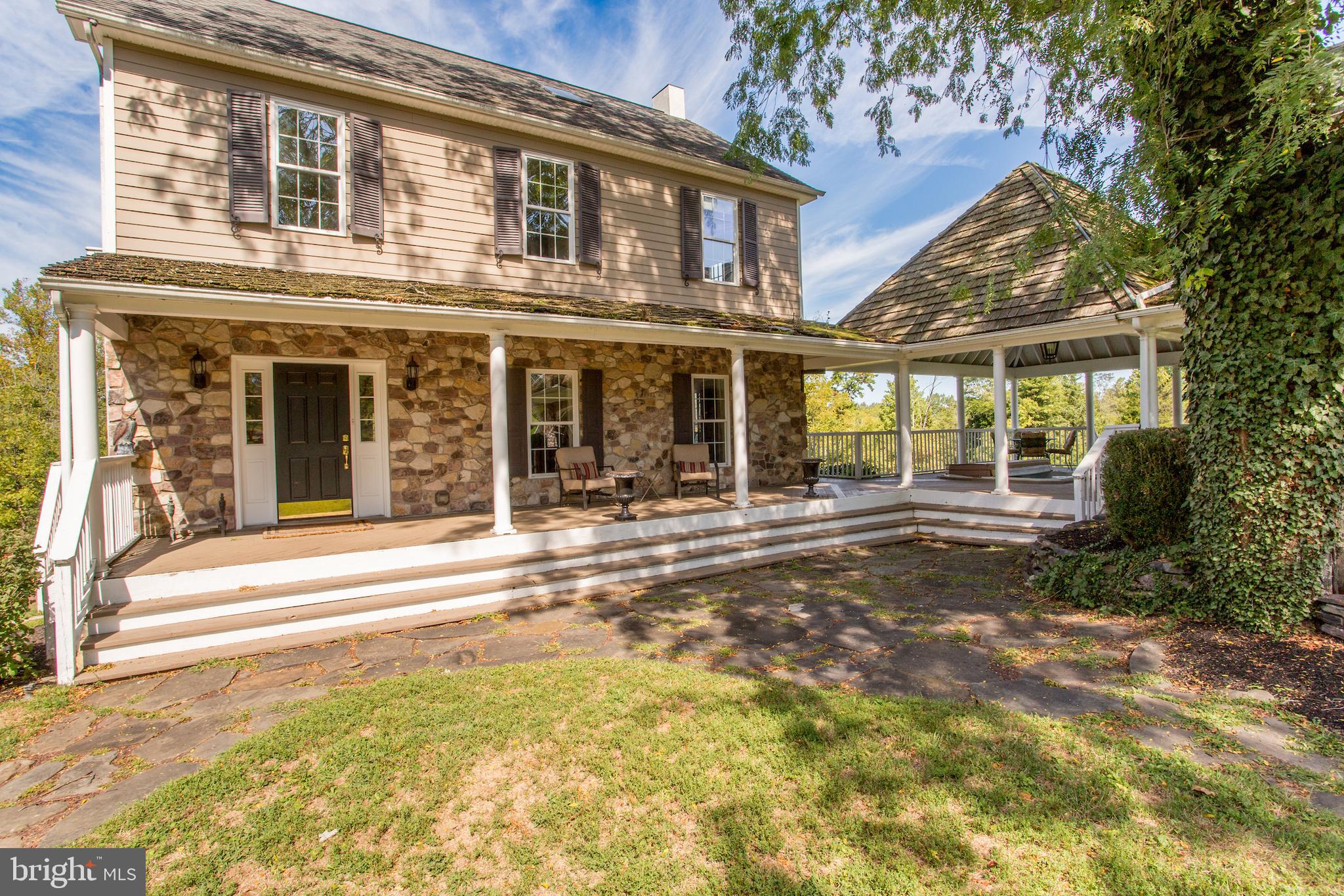 3605 Windy Bush Road New Hope, PA 18938 - Photo 4 of 55 a view of a brick house with large windows and a large tree