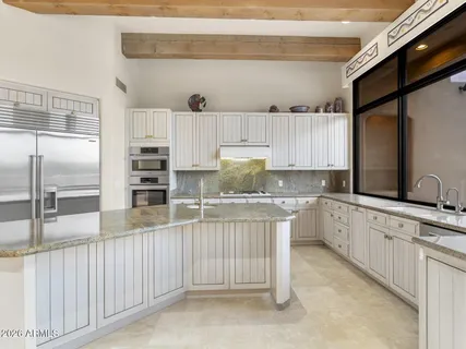a sink with granite countertop cabinets