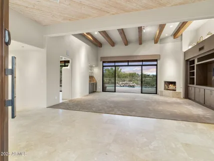a view of an empty room with a fireplace and a window