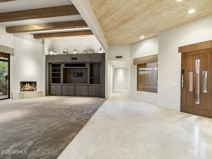 a view of an empty room with a fireplace and a window
