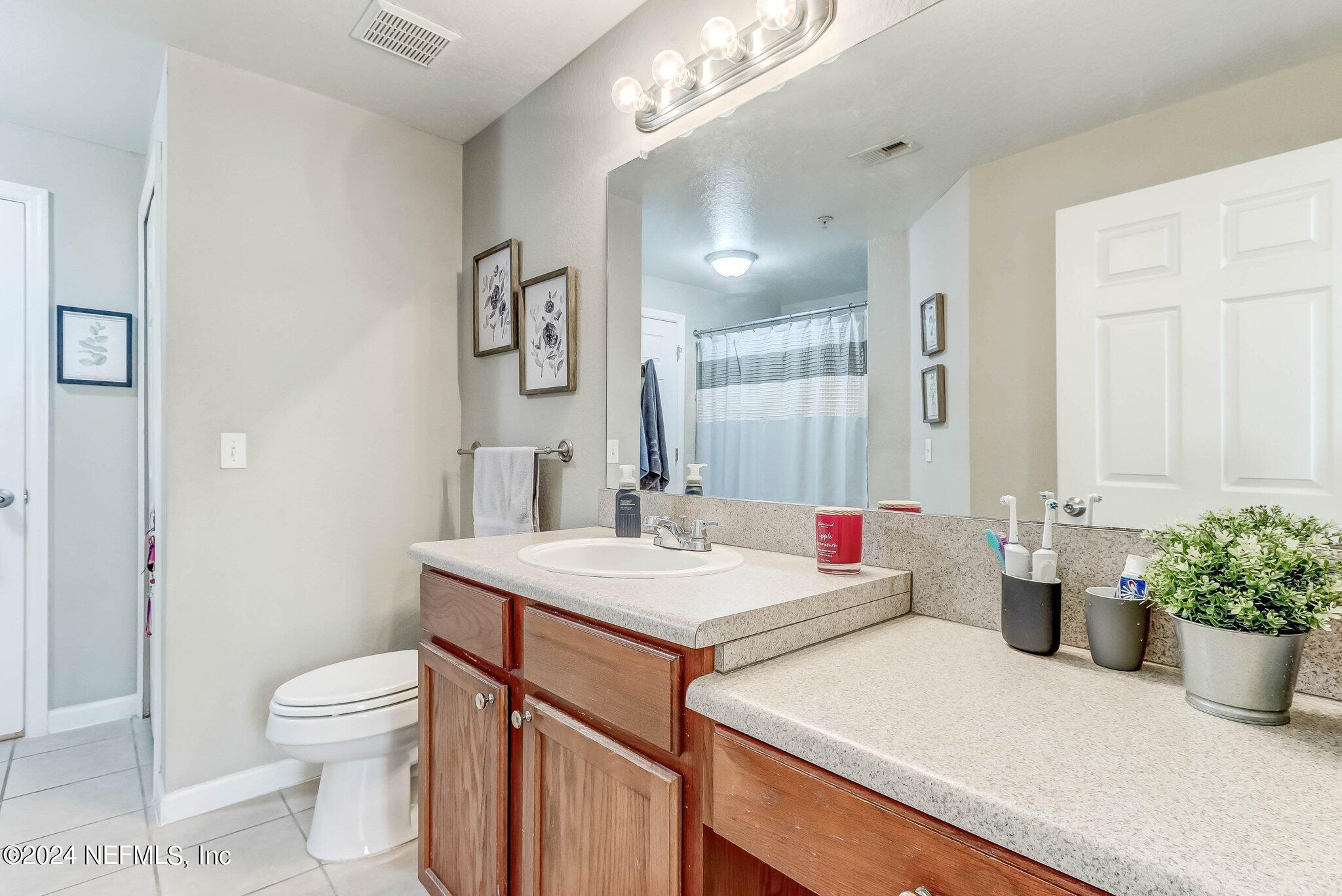 8550 Touchton Road, Unit 1423 Jacksonville, FL 32216 - Photo 16 of 36 a bathroom with a sink toilet vanity and shower
