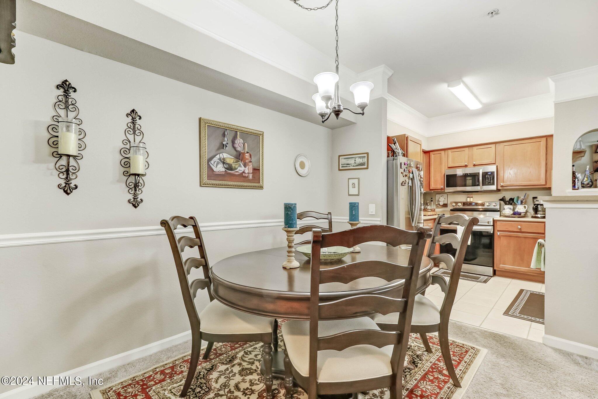 8550 Touchton Road, Unit 1423 Jacksonville, FL 32216 - Photo 5 of 36 a view of a dining room with furniture and a chandelier