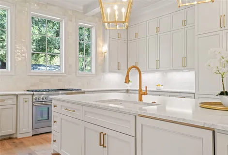a kitchen with granite countertop white cabinets and a sink