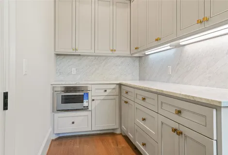 a kitchen with white cabinets and white appliances
