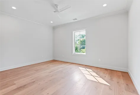 an empty room with windows and ceiling fan