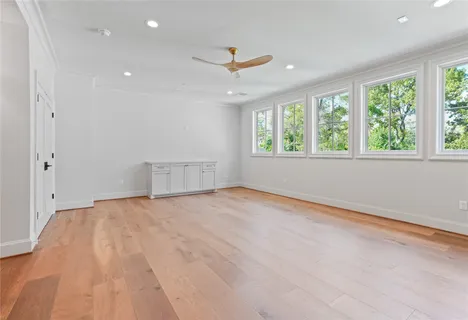 an empty room with wooden floor and windows