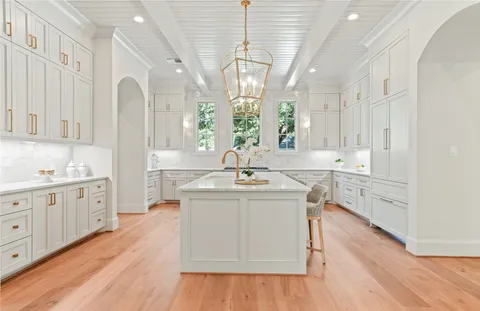 a spacious bathroom with a granite countertop sink a mirror and a bathtub