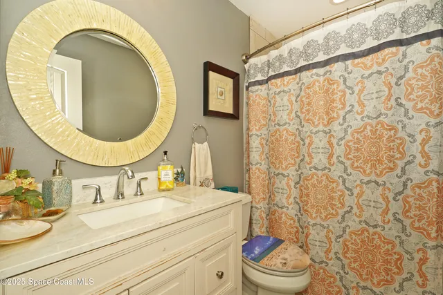 a bedroom with a bed chandelier and a window