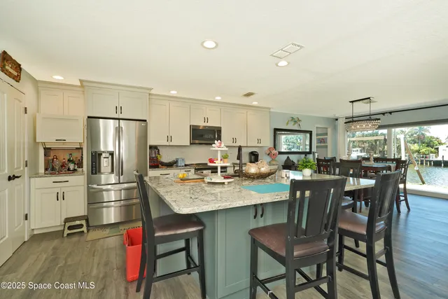 a kitchen with refrigerator cabinets dining table and chairs