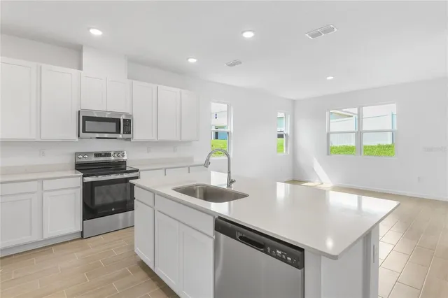 a kitchen with granite countertop a sink and white cabinets