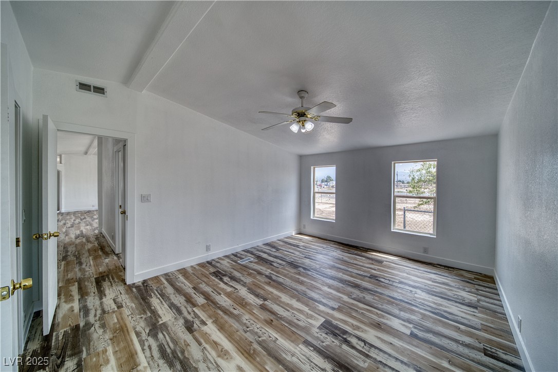 1340 South Adams Road Pahrump, NV 89048 - Photo 13 of 31 Spare room featuring wood finished floors and a ceiling fan