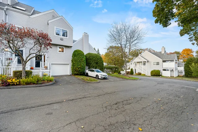 a view of white house with a yard and garage