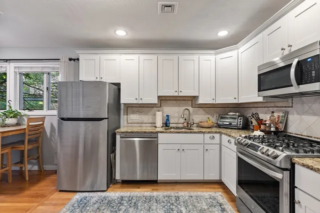 a kitchen with stainless steel appliances granite countertop a refrigerator sink and cabinets