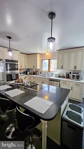 a kitchen with sink a stove and chairs