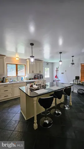a kitchen with kitchen island granite countertop a sink and a stove