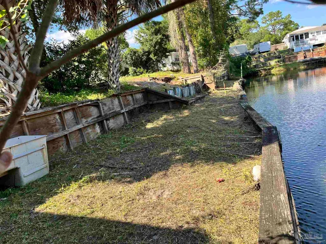 a view of a house with a yard and potted plants