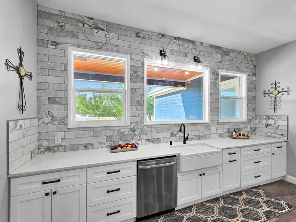 a large kitchen with lots of counter space a sink appliances and dining table