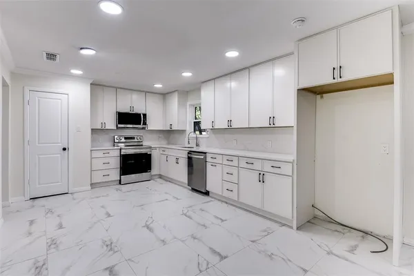 a kitchen with granite countertop cabinets and white stainless steel appliances