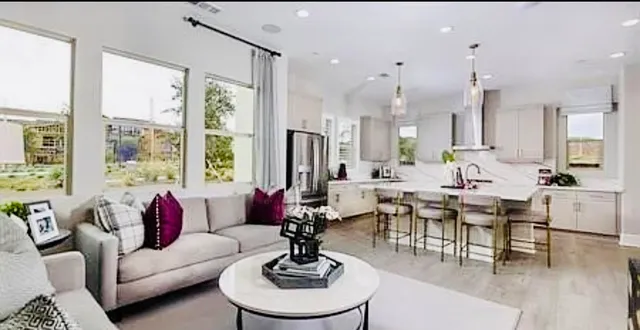 a living room with furniture large window and chairs
