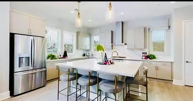 a kitchen with stainless steel appliances a dining table and chairs