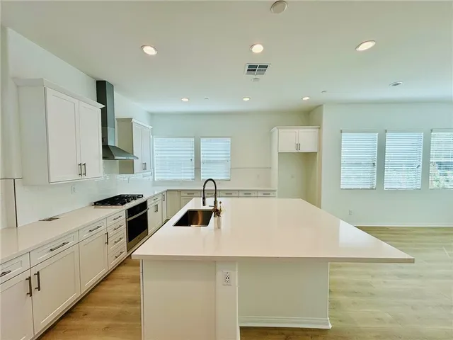a kitchen with a stove a sink a microwave and cabinets