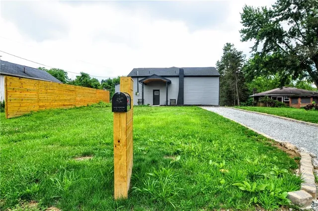 a brick house with a big yard and large trees