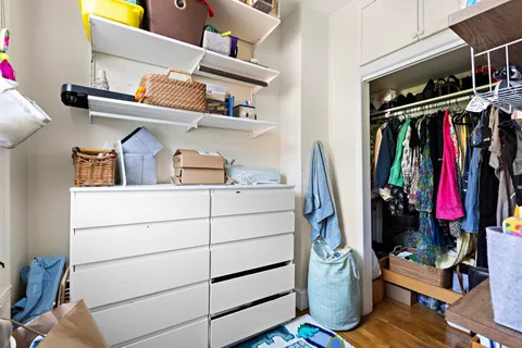 a view of walk in closet with clothes and shoes