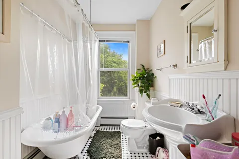 a bathroom with a granite countertop sink and a bathtub