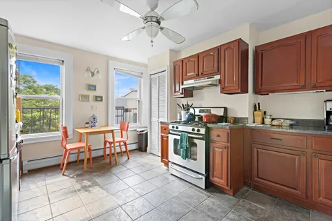 a kitchen with stainless steel appliances granite countertop a stove top oven a sink dishwasher and cabinets with wooden floor