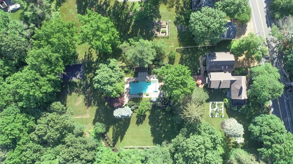 an aerial view of residential house with outdoor space and trees all around