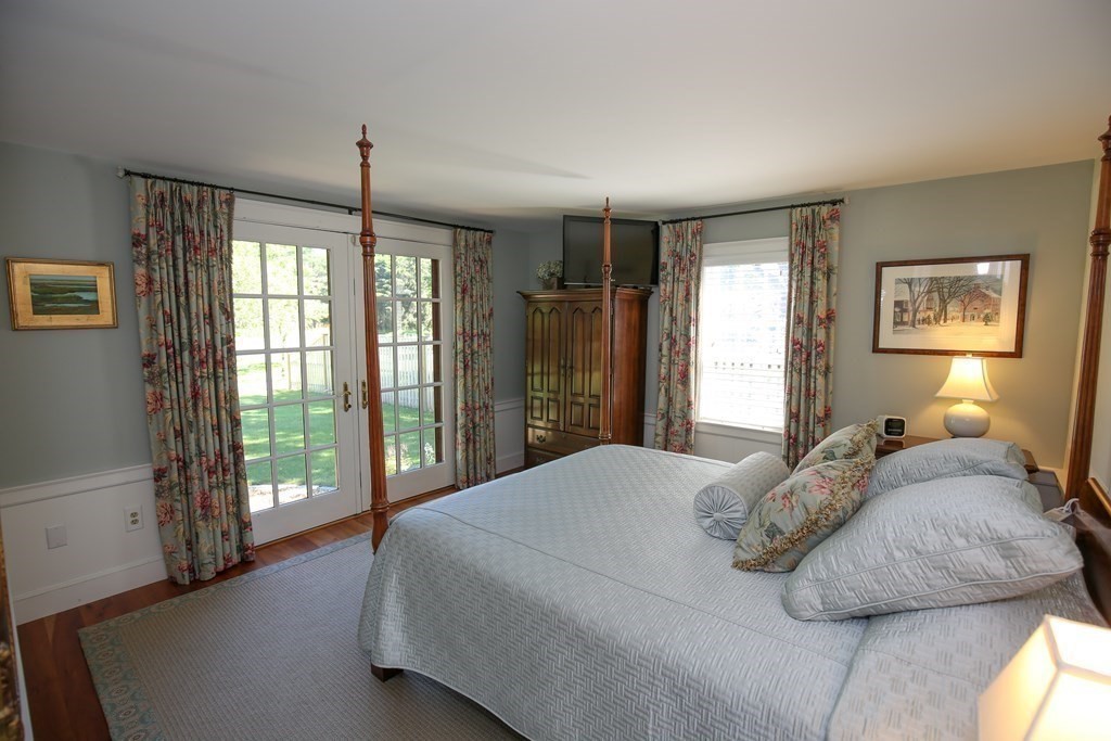 21 Rolfe's Lane Newbury, MA 01951 - Photo 26 of 42 a bedroom with a large bed and a chandelier