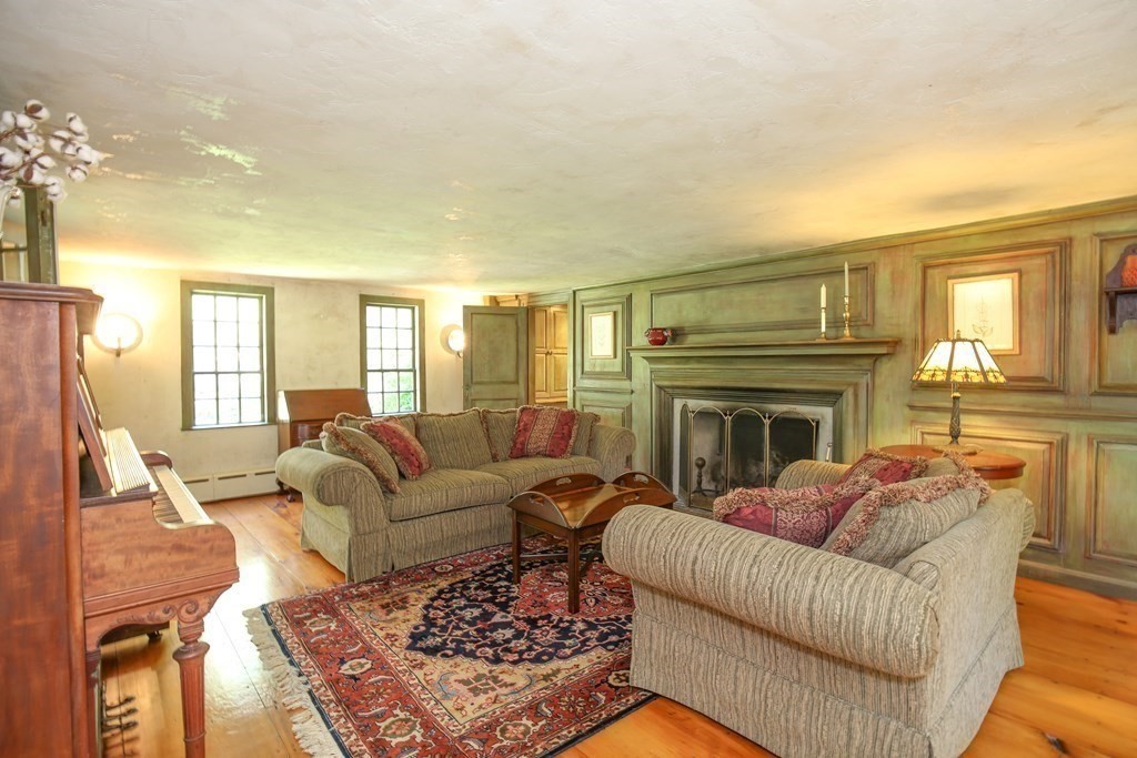 21 Rolfe's Lane Newbury, MA 01951 - Photo 10 of 42 a living room with furniture a fireplace and a dining table with wooden floor