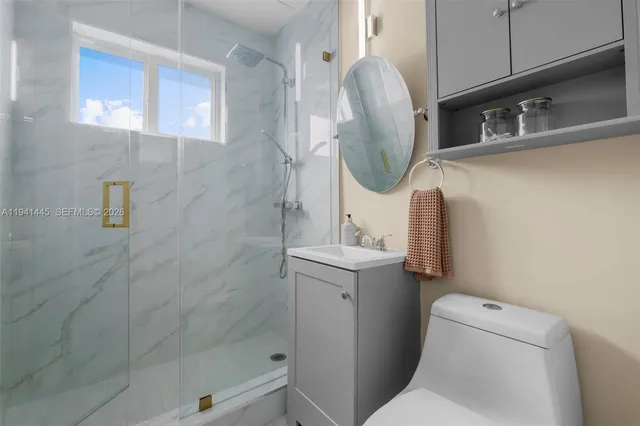 a bathroom with a sink a toilet and shower