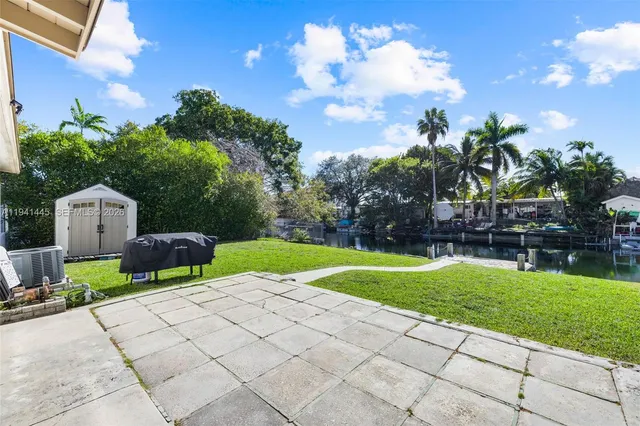 a view of a chairs and table in the back yard of the house