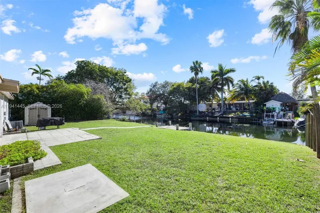 a swimming pool with barbeque oven outdoor seating and yard