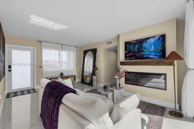 a living room with furniture a fireplace and wall paintings