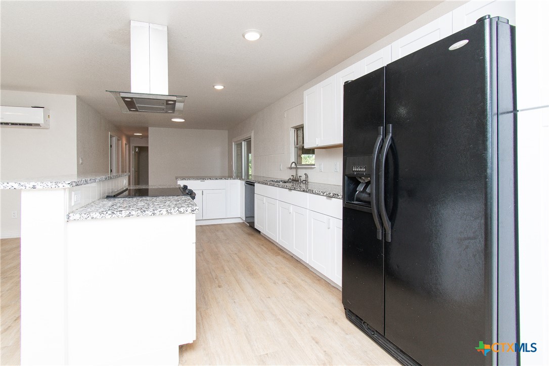 199 Apache Springs Road Briggs, TX 78608 - Photo 6 of 28 a kitchen with stainless steel appliances kitchen island granite countertop a refrigerator and a sink