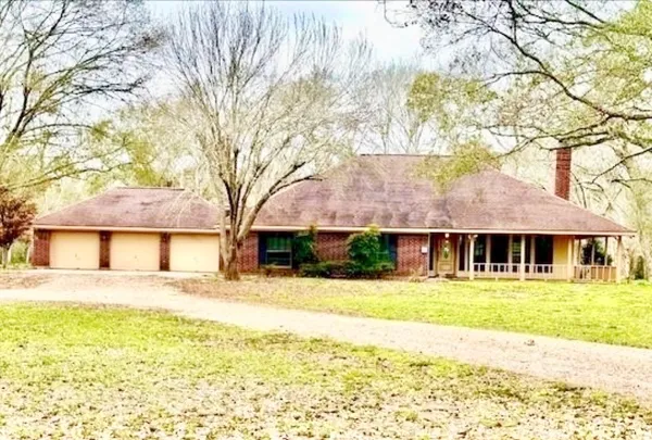 a front view of house with yard and trees around